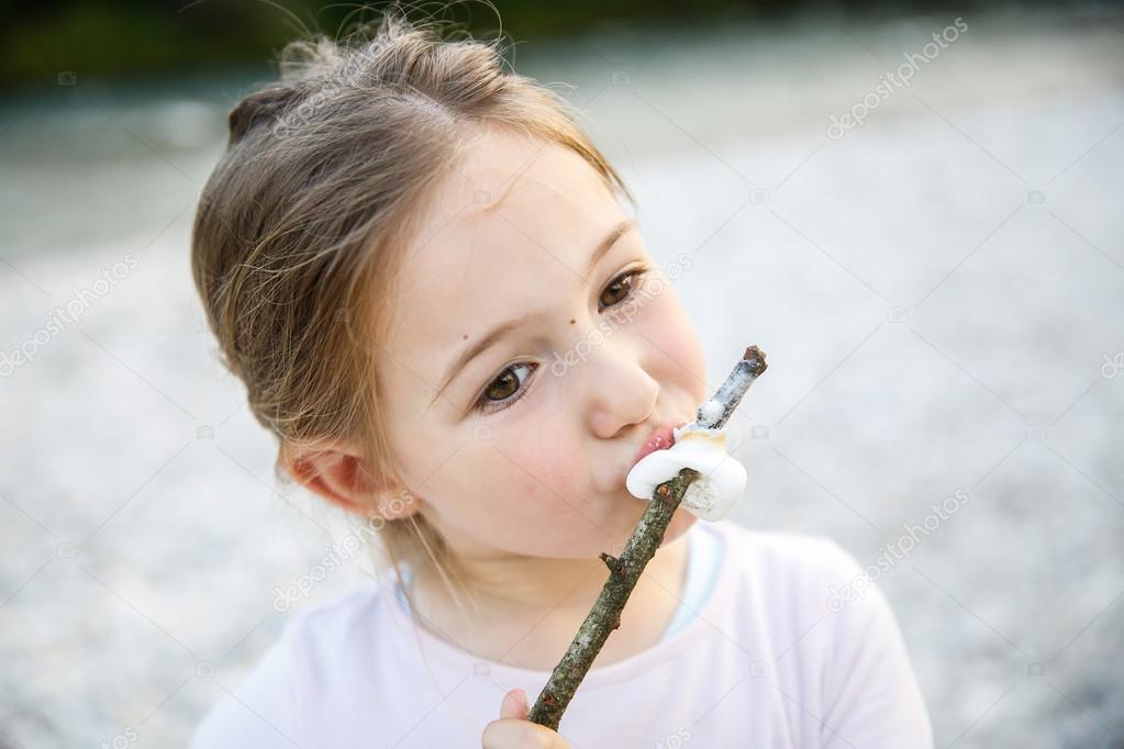 Little girl eating roasted marshmallow