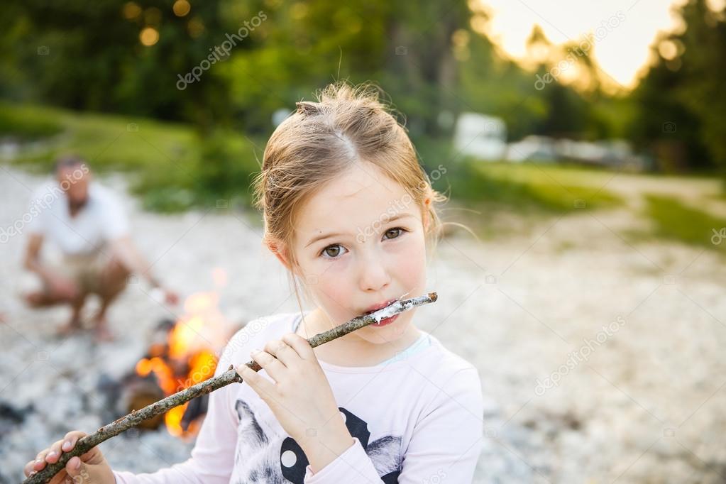 Little girl eating roasted marshmallow