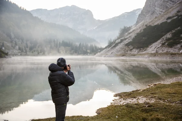 Fotograf hält eine Kamera in der Hand und macht Fotos — Stockfoto