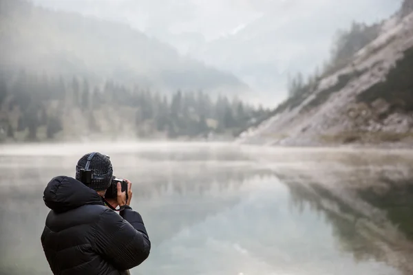 Fotograf hält eine Kamera in der Hand und macht Fotos — Stockfoto