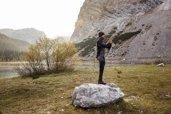 Mann praktiziert Yoga, führt eine Baumstellung aus — Stockfoto