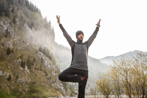 Mann praktiziert Yoga, führt eine Baumstellung aus — Stockfoto