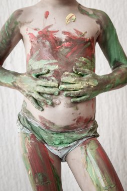 Child body painting himself with finger paints clipart