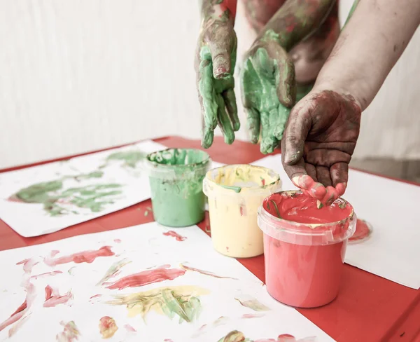 Niños sumergiendo los dedos en pinturas lavables para los dedos — Foto de Stock