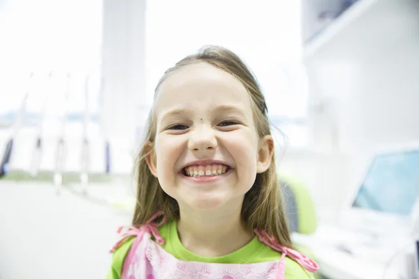 Menina mostrando seus dentes de leite saudáveis no consultório odontológico — Fotografia de Stock