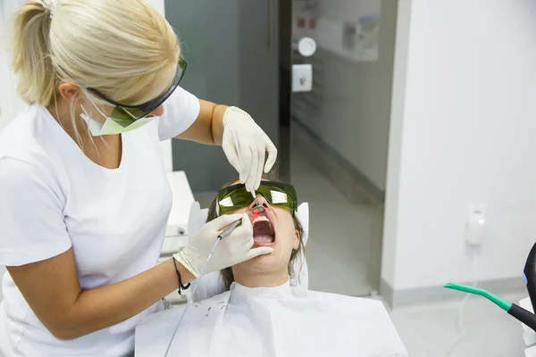 Dentista usando un láser dental de diodo moderno — Foto de Stock