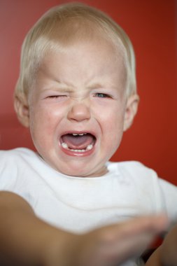Small, crying toddler in pain after falling down clipart
