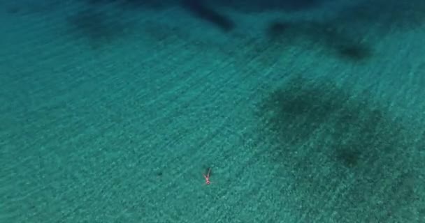 Letecký snímek nové, úžasně tyrkysové moře vody, s ženou ležící v ní, léto, slunce a písku. — Stock video
