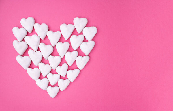 Love copy space concept idea with big heart made from small white hearts on pink a background. Minimal flat lay.