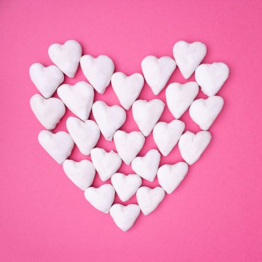 Pembe arka plandaki küçük beyaz kalplerden yapılmış büyük bir kalple kare aşk fikri. Minimum düzlük.