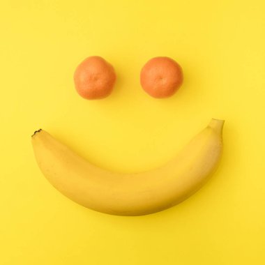 Yaz tropik düz konsept yaratıcı yatıyordu. Canlı bir arka planda sarı muz ve turuncu mandalinadan olumlu bir gülümseme..