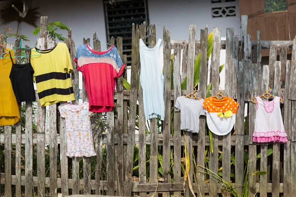 Colorful clothes hanging to dry on wooden fence — Stock Photo, Image