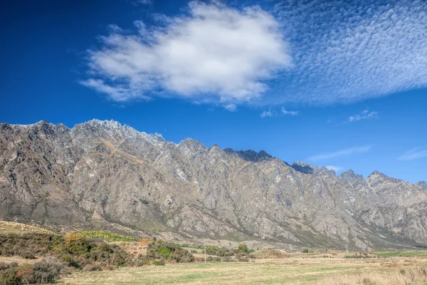 Paesaggio nuvoloso sopra la montagna e il campo verde — Foto Stock