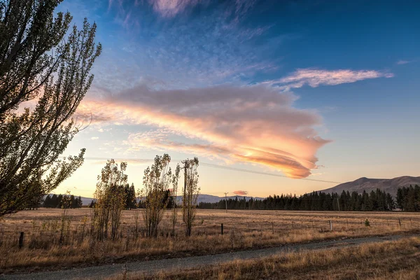 Sunrise behind grass land — Stock Photo, Image