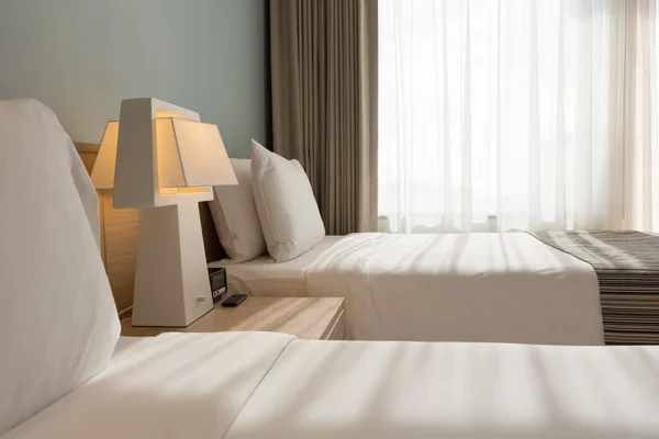 Quarto de cama com almofadas brancas, lençóis e cortina — Fotografia de Stock
