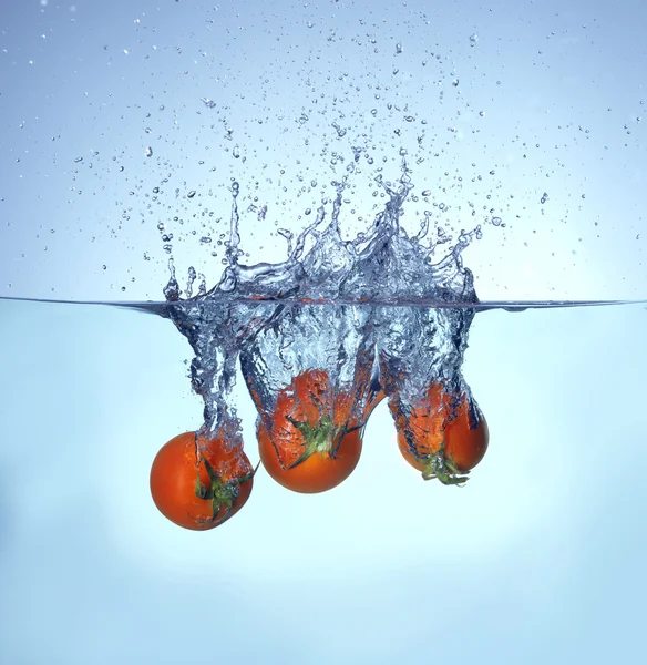 Tomato falling and splashing into water — Stock Photo, Image