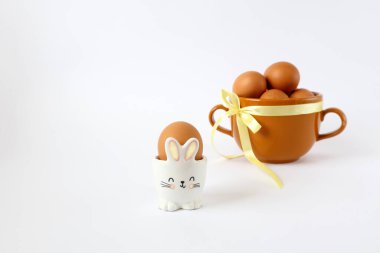 Tavşan şeklinde tavuk yumurtası beyaz arka planda yumurtaları olan bir bardağın arka planında, mesaj için yer var.