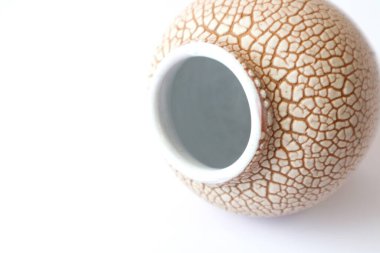 Sarı kabartma desenli seramik kap, beyaz arka plan, yakın plan