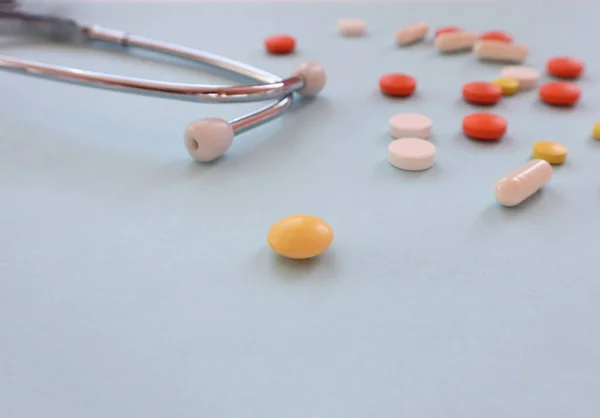 A pressure measuring device , multi-colored tablets and ampoules on a blue background, a place for text - the concept of taking care of your health