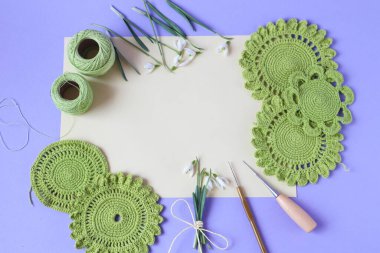 Yeşil renkli dikiş motifleri, dikiş aletleri, arka planda kar damlası çiçekleri, üst görünüm, metin için yer