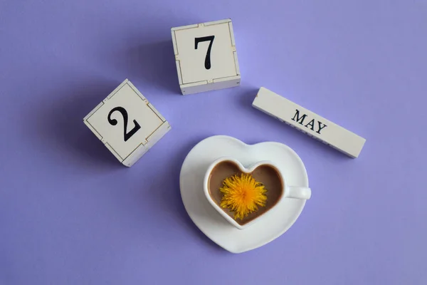 五月二十七日的日历 用数字27表示立方体 用英语表示五月的名字 一杯心形咖啡 上面有蒲公英花 俯瞰全景 — 图库照片