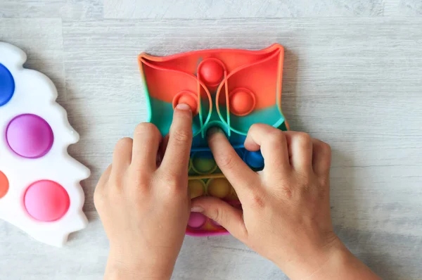 Stres önleyici oyuncaklarla çocuklarla vakit geçirme kavramı. Oyuncağı olan bir çocuğun elleri, üst görünümü, yakın plan.