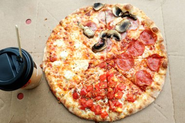 Hızlı atıştırmalık konsepti. Karton pakette pizza, süpermarketin masasında bir bardak kahve, yakın çekim, üst manzara.