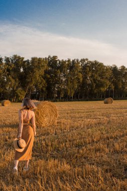Samanlıkların arka planında bir kız