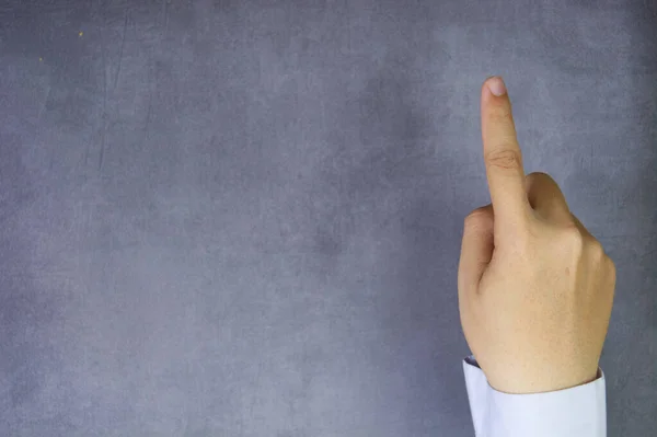 Taklit beton arka planda bir parmağı olan bir iş adamı rolünü oyna