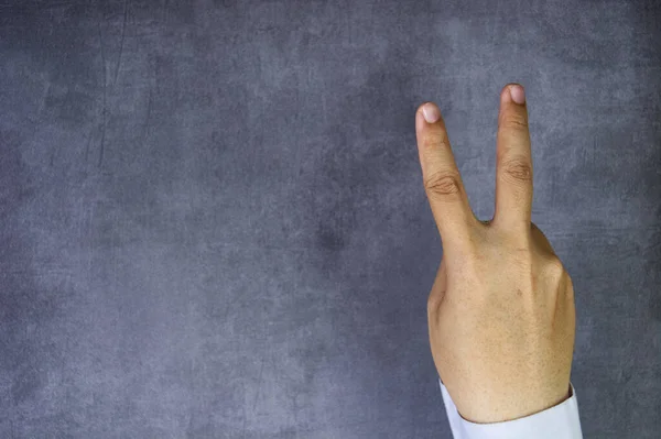 Taklit beton arka planda iki parmağı olan bir iş adamı rolünü oyna
