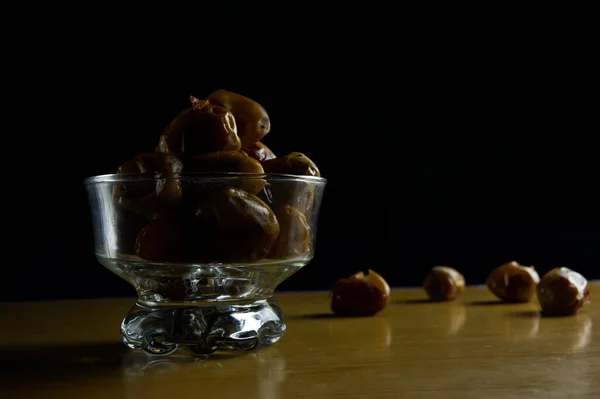 Siyah arka planda beyaz bardakta tatlı bir yemek.