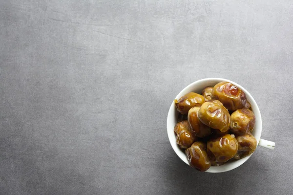 Sahte çimento arka planında beyaz bardakta tatlı bir yemek.