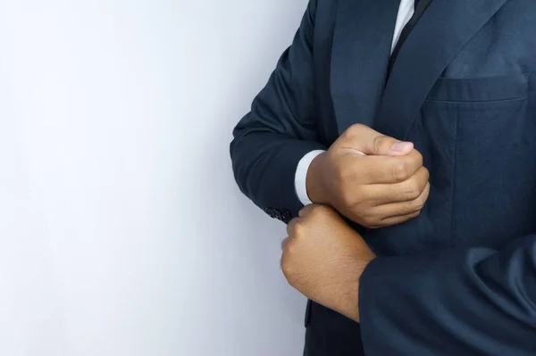 İş adamı rolünü oynayan biri gömleğini düzeltiyor.