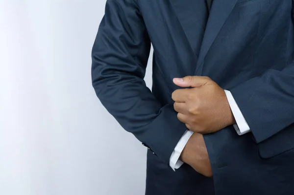 İş adamı rolünü oynayan biri, kıyafetlerini düzeltiyor.