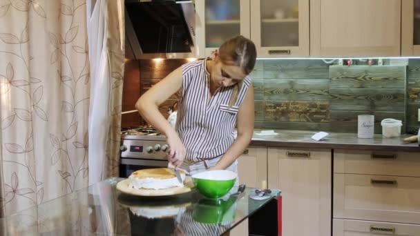 Kvinna att sätta grädde på en svamp kaka för hand med hjälp av pallete kniv. — Stockvideo