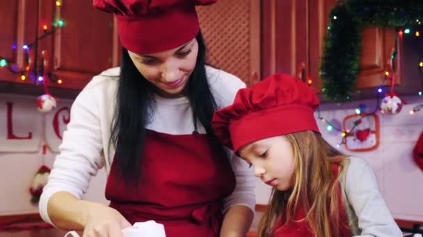 En dotter tillsätter i skålen socker och mamma blandar ingredienser med mixer — Stockvideo