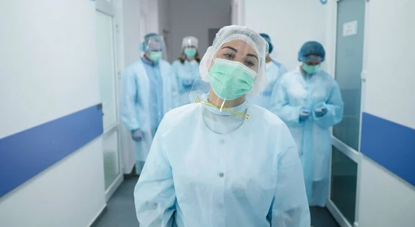Koruyucu Takım Elbiseli Doktorlar Takımı. Tıbbi İşçiler Modern Hastanenin Koridorunda Maskeli Yürüyüş. Covid-2019 ile savaşıyorum. Klinikteki doktorlar.