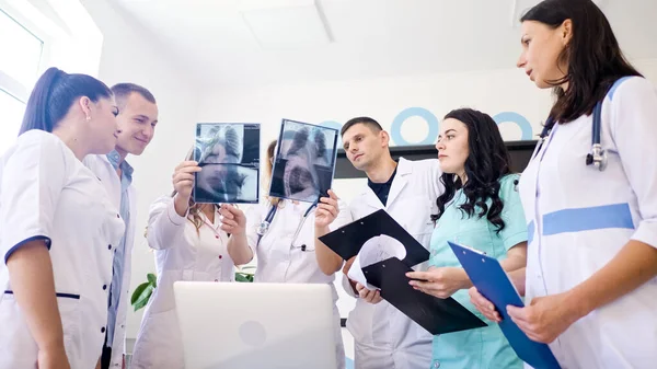 Kvinnliga läkare och unga läkare i medicinsk klädsel Studera tillsammans resultaten Bröst röntgenskanning av patienten. Medelålders kvinna terapeut Undervisa unga praktikanter Hur man analyserar röntgenbild — Stockfoto