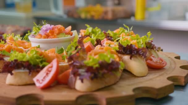 Close-up. Sanduíches bonitos, Mistura de folhas de alface fresca e legumes brilhantes em uma bandeja de madeira decorativa, Bruschetta feita de produtos orgânicos, Conceito de comida saudável e deliciosa. — Vídeo de Stock