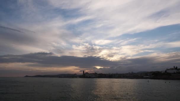 水面近くの夕日の街のスカイライン。空にいくつかの雲. — ストック動画