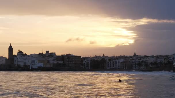 Silhouette a group of surfers paddling over a ocean wave surf session during sunset — Stock Video