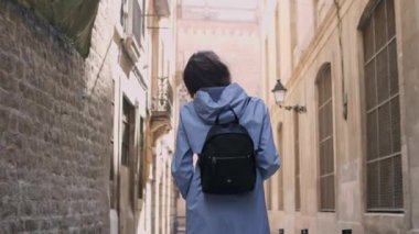 Sırt çantalı bir kızın dar sokaklardan geçişi..