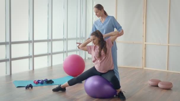 Ärztin hilft schwangerer Frau bei Ballübungen — Stockvideo