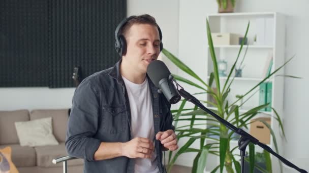 Ein Mann singt ein Lied mit einem Lächeln im Gesicht. Home Entertainer, Blogger-Konzept. — Stockvideo