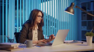 Bir İş Kadını Modern Ofiste Geç Saatlere Kadar Çalışıyor, Pozitif Atmosferi Koruyor ve İş-Yaşam Dengesi İçin Çabalıyor. Akşam Verimliliği, İşyeri Refahı, Teşvik Edici Çevre.