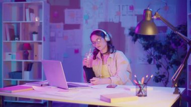 Dikkatli Yaratıcılık, Duygusal Odaklanma, Gen Z Tarzı. Kulaklıklı Kadın, Gece Müzik Dinlerken Neon Room 'da Çizim Yapıyor. Kişisel İlham Anı, Sakin ve Etkileyici Akış