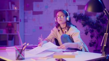 Yaratıcı Endüstriler, Geleceğin Meslekleri, Dijital Gençlik. Neon Room 'daki Genç Kız ödev ya da Yaratıcı Proje üzerine çalışıyor. Kişisel Alandaki Tasarım, İçerik veya Kodlamadan Odaklanmış ve İlham Almış