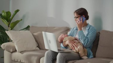 Esnek kariyerler. Genç Anne, bebeğe bakarken kariyer adaptasyonunu ve uzaktan çalışmayı dengeler, ebeveynlere modern iş esnekliği gösterir.