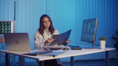 Masa ve Bilgisayar Ekranında Kadın Doktor Çalışmaları MRI Taramaları Gelişmiş Tıbbi Teşhis ve Araştırma Yönetimi. Yenilik, Hassasiyet Sağlık ve Bilimsel Tıbbi Analiz Konsepti.