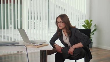 Melez Çalışma Modeli ve Çalışan Sağlığı. Ofis Müdürü, Gerginliği azaltmak, Esnekliği Artırmak, Sağlıklı Duruş ve Dengeyi Desteklemek ve Verimliliği Artırmak İçin Masada Oturmuş Kalça ve Bel Bel Bel Esnetme Uygulaması Yapıyor